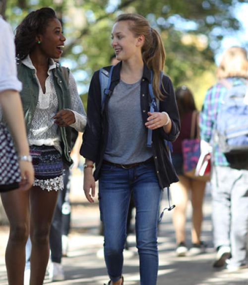 Two young women talking and walking on Morris campus