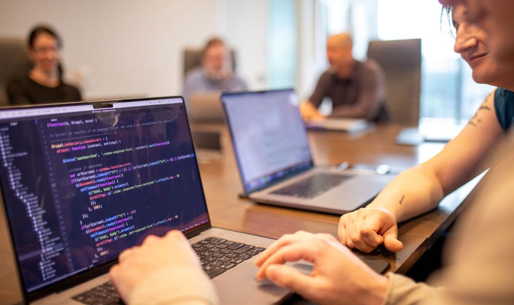 two developers reviewing code on a laptop