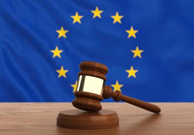 judge gavel on a desk with the European Union flag in the background
