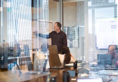 adult man presenting to a group of coworkers in a conference room
