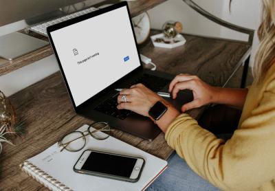 adult woman working on a laptop whose screen is pure white with a single message that says "this page isn't working"