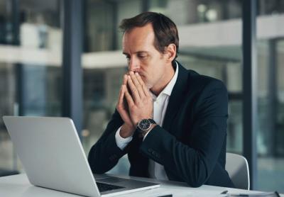 person staring at their laptop with deep concern
