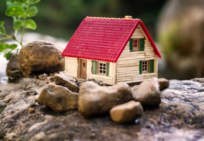 small model of a tiny house set among rocks outside