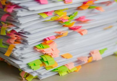 very large stack of papers on a table