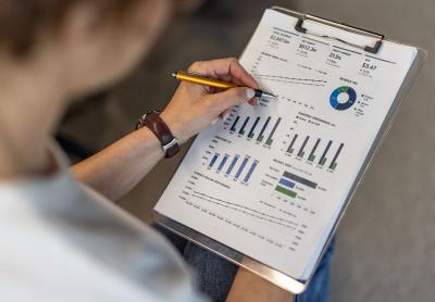 Woman reviewing a printed page with various analytics and graphs