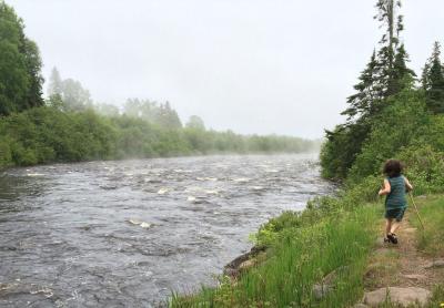 youth running alongside a running river in Minnesota