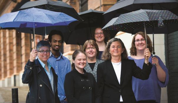 staff of legal state support, outside with umbrellas in their hands