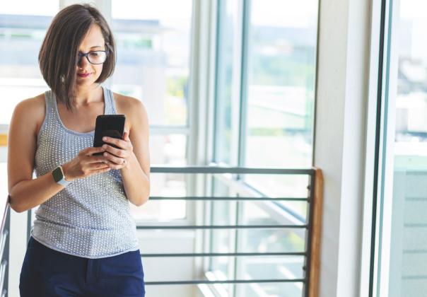 woman at the office searching the web with her smartphone