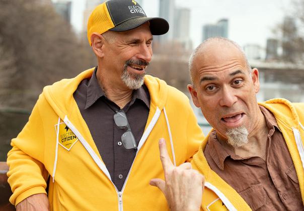 Citizens Wilbur and David on a bridge in front of the Austin skyline