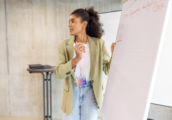 business woman tracking scores on a board in conference room