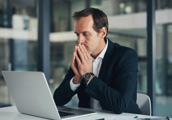 person staring at their laptop with deep concern
