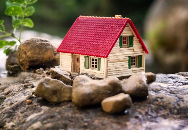 small model of a tiny house set among rocks outside