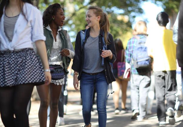 Two young women talking and walking on Morris campus