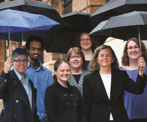 staff of legal state support, outside with umbrellas in their hands