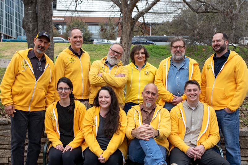 group photo of the Electric Citizen team, outdoors and wearing gold hoodies