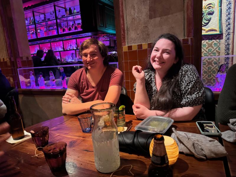 two team members at dinner together, seated at table