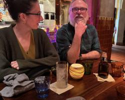 two team members at dinner together, talking over drinks