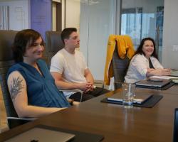 three EC team members seated at a conference room table