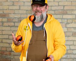 Tim juggling balls while wearing EC gold apparel