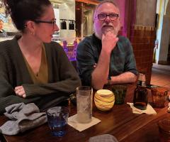two team members at dinner together, talking over drinks