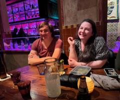 two team members at dinner together, seated at table