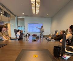adult male presenting slides in a conference room