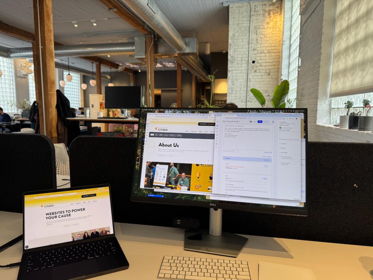 laptop and monitor on a desk facing out to a bright office scene