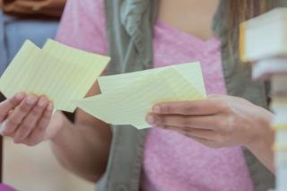 close up of adult person holding notecards in their hands