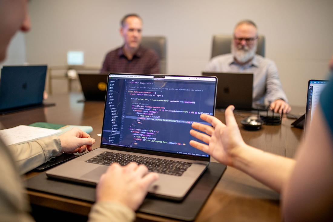laptop with code on a conference room table