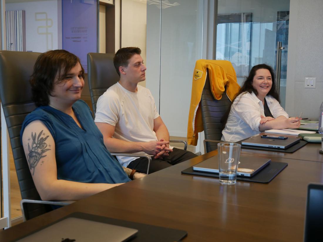 three EC team members seated at a conference room table